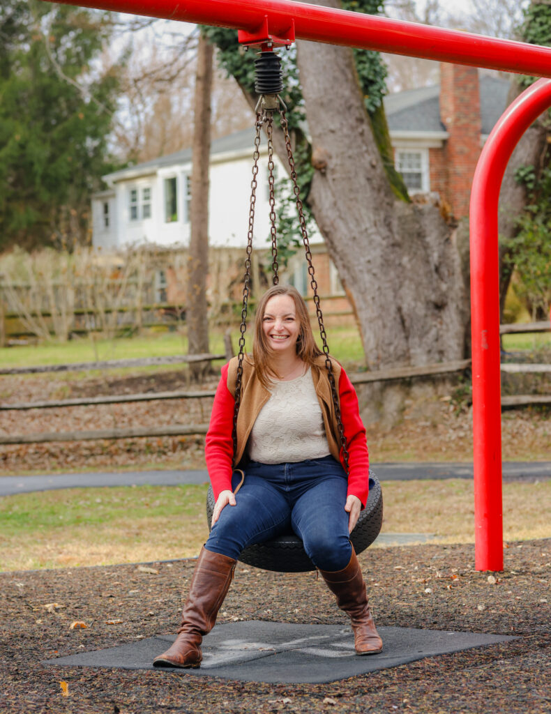 Woman sitting on tire swing and smiling